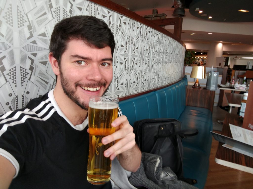 Jack holding a beer in Manchester Airport.